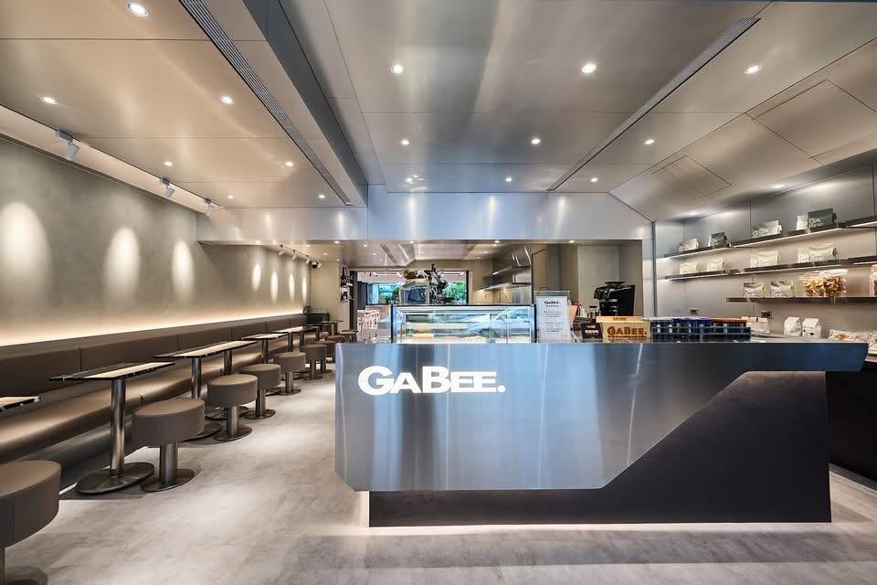 The sleek stainless steel GaBee. counter inside the Songshan shop, with banquette seating along one wall and pastry cases behind the bar