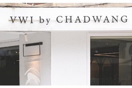 The white corner storefront of VWI by CHADWANG with raised VWI by CHADWANG lettering above glass windows onto the brewing bar