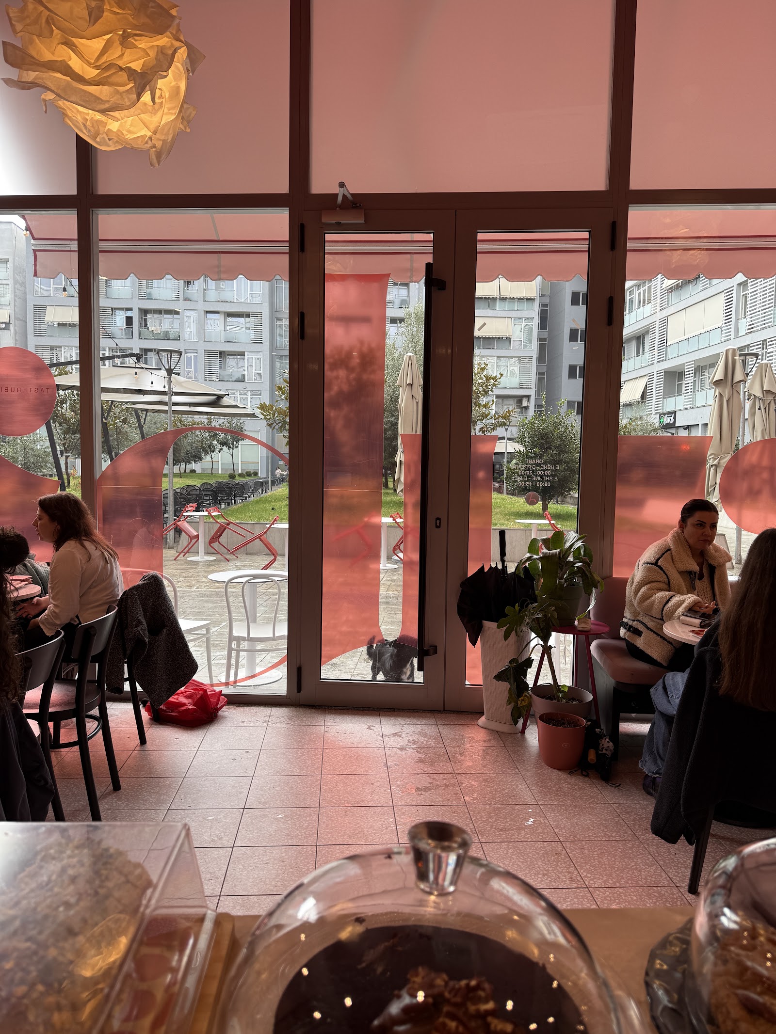 The pink toned interior of RUBI Cakes and Specialty Coffee with floor to ceiling windows and high stool seating
