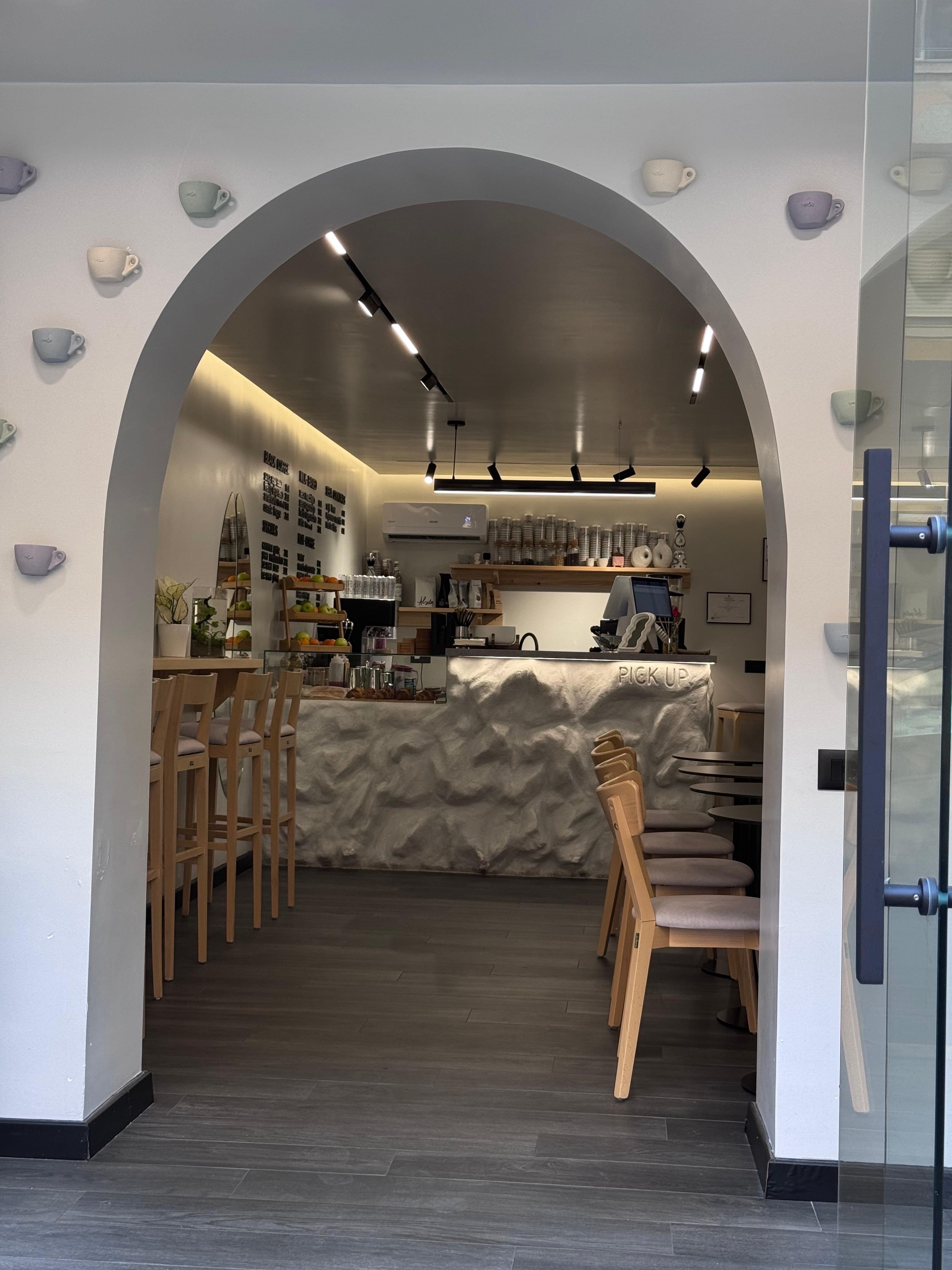 The arched doorway and stone counter of SECA Coffee's clean minimal interior