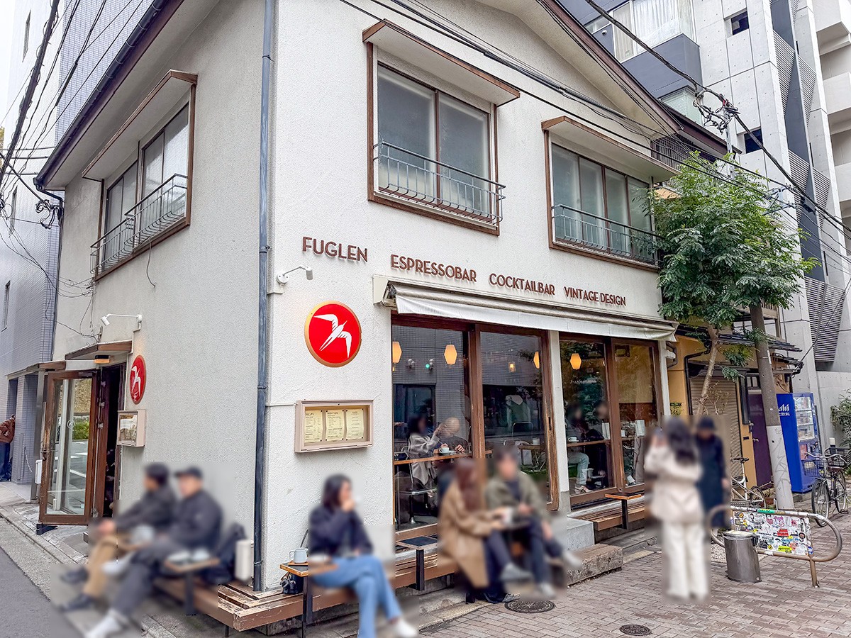 The corner exterior of Fuglen Tokyo with its red swallow logo and Espressobar Cocktailbar Vintage Design signage, benches out front