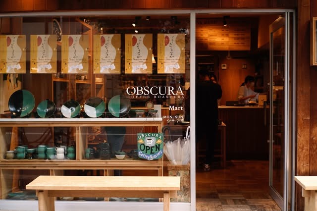 The window storefront of an Obscura Coffee Roasters shop near Sangenjaya Station, with the brand's wordmark on the glass and pottery displayed in the window