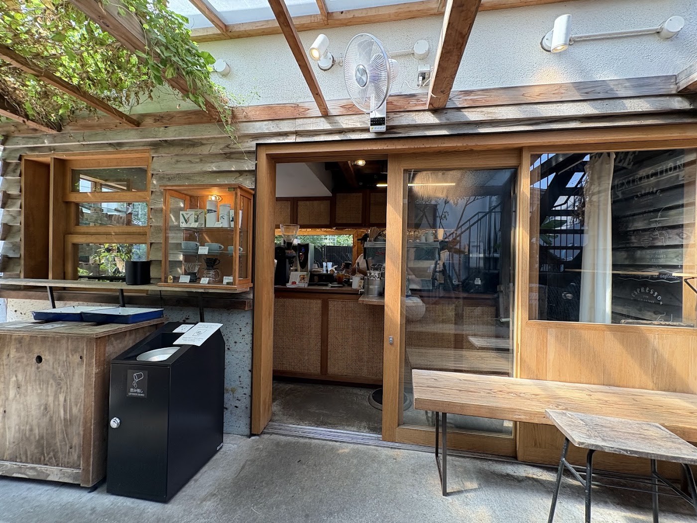 The wooden storefront of Onibus Coffee with retail cups and pour over gear displayed in a window case beside the entrance