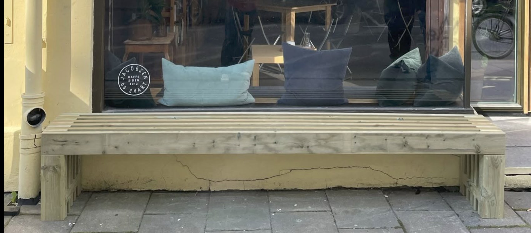 The outdoor bench seating beneath the branded Jacobsen og Svart window decal