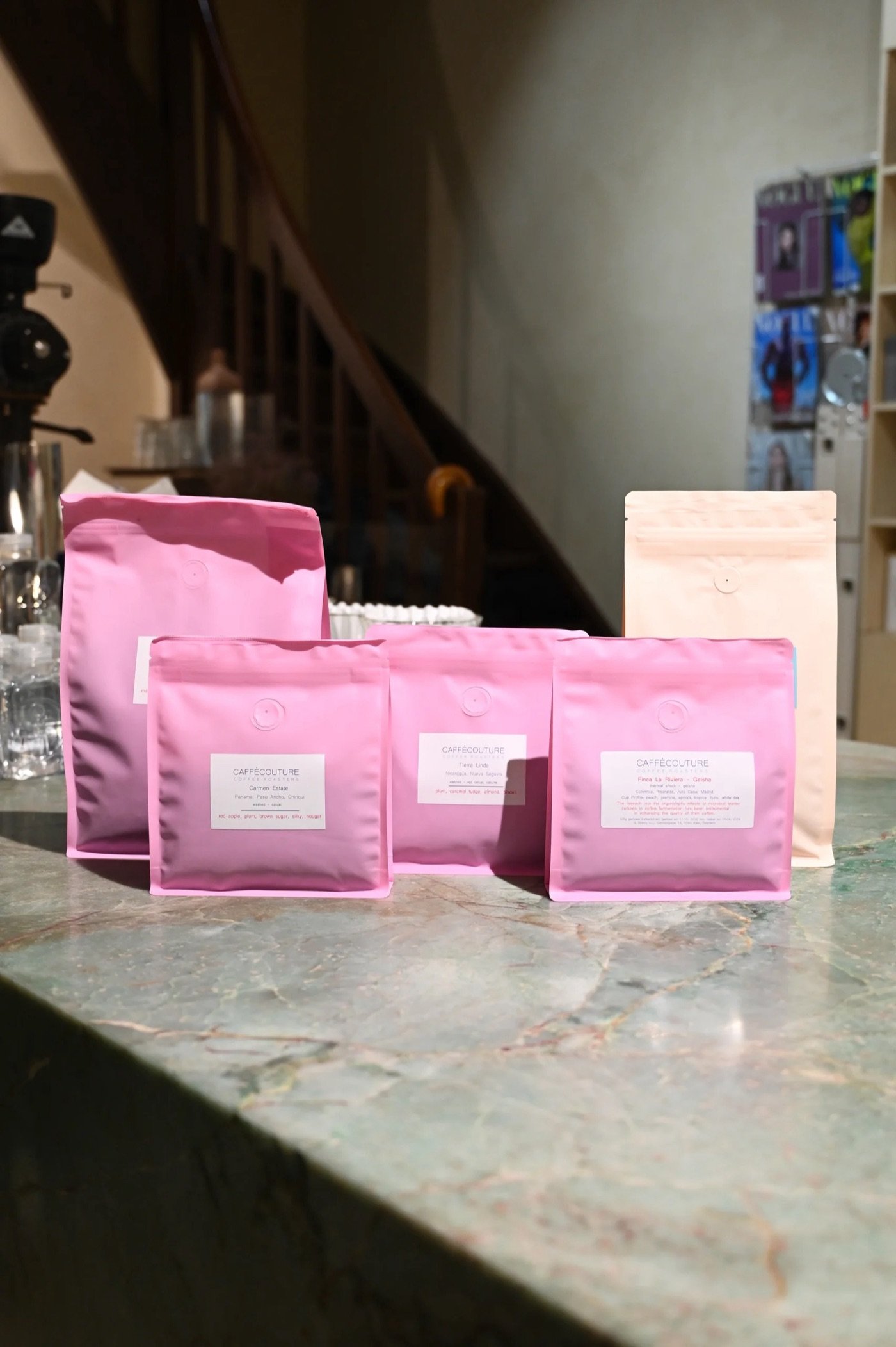 Pink CaffèCouture retail bean bags lined up on a marble counter inside Palais Ferstel