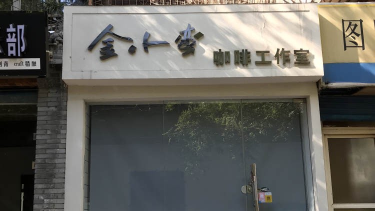 The studio's white storefront with its metal sign reading Jinxiaoman Coffee Studio above a glass entrance