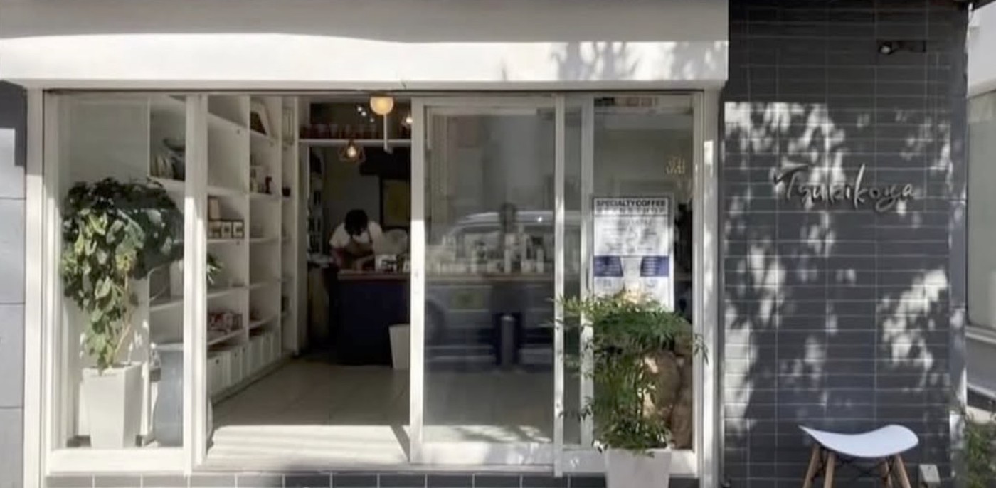 The open glass storefront of Tsukikoya with potted plants out front and shelves of retail bags and gear visible inside
